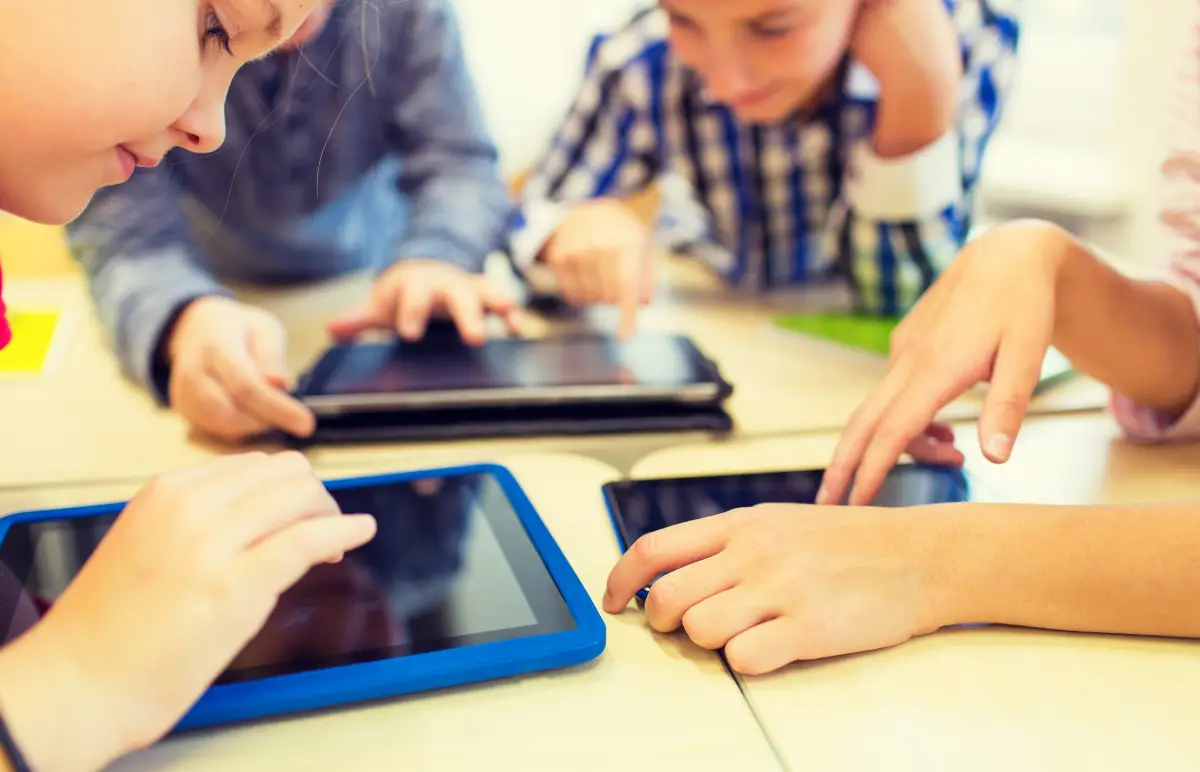 Educação Digital - crianças debruçados sob tablets