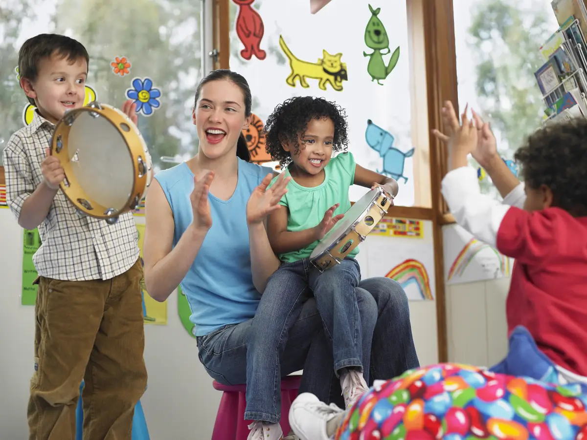 Importância musicalização na educação infantil - professora cercada de crianças tocando instrumentos